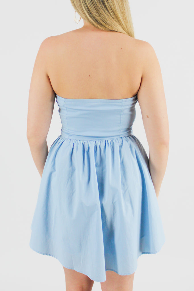 back photo of a light blue corset dress with a fitted top and a flowy bottom.