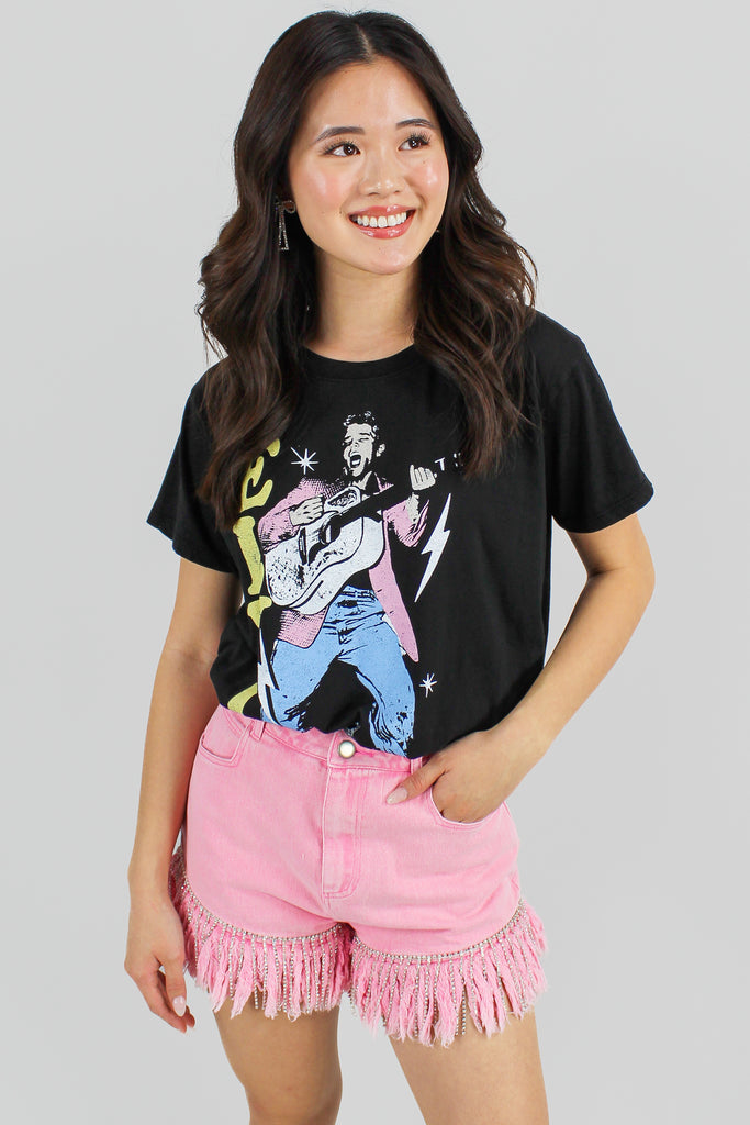 black elvis presley graphic tee with pink denim shorts and cowboy boots