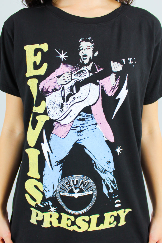 black elvis presley graphic tee with pink denim shorts and cowboy boots