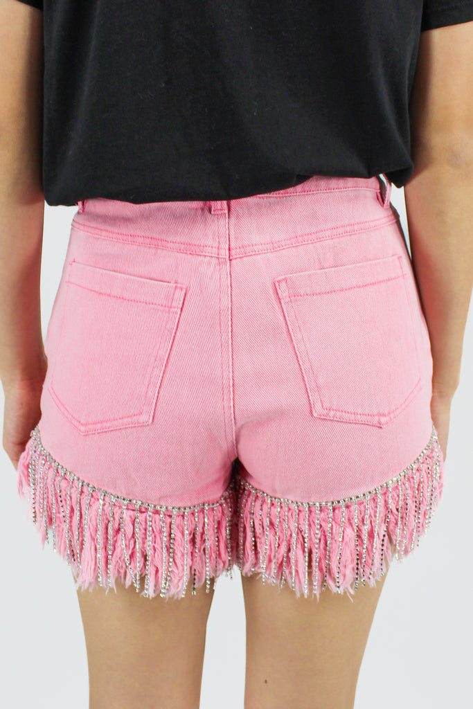 pink denim shorts with a frayed hem and rhinestone fringe