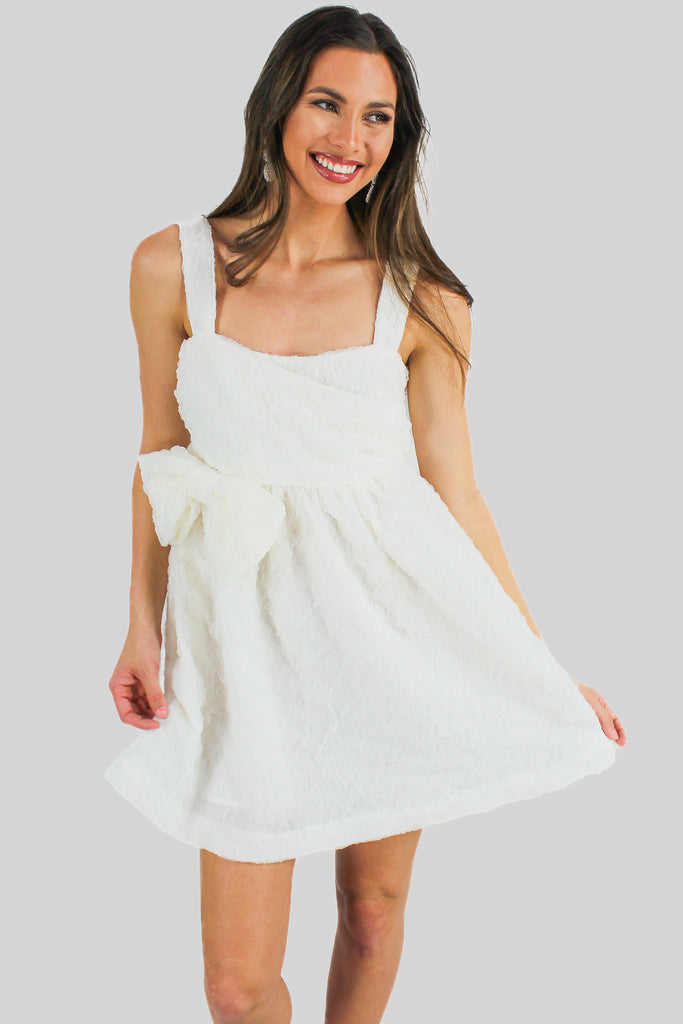 off white textured dress with a bow detail on the left side