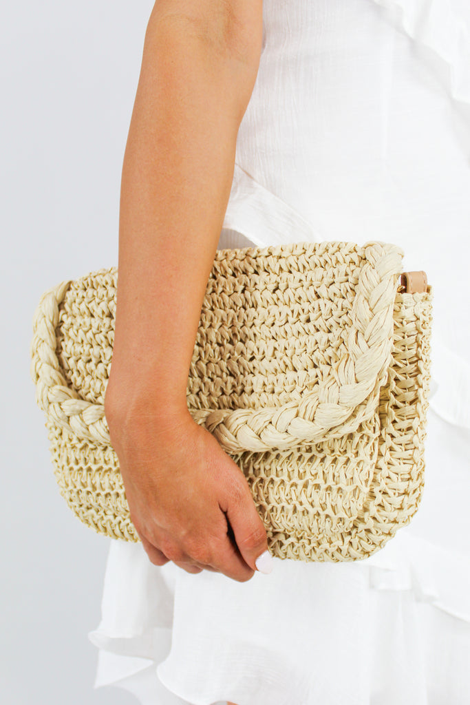 sand colored straw raffia clutch with a removable and adjustable strap