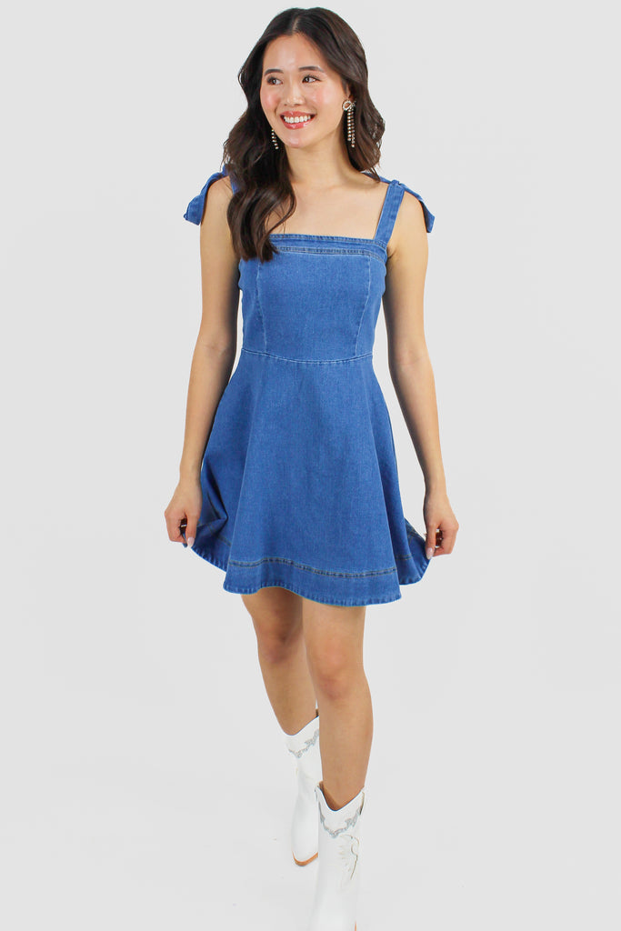 front view of a denim dress with tie straps 