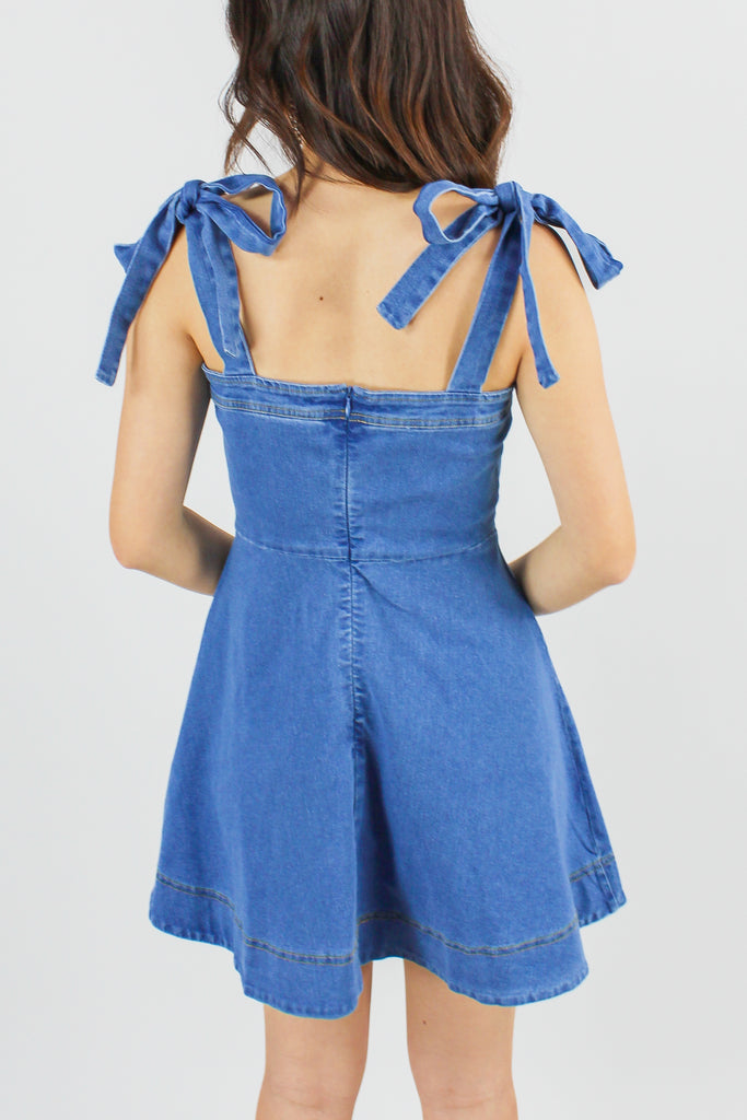 front view of a denim dress with tie straps 
