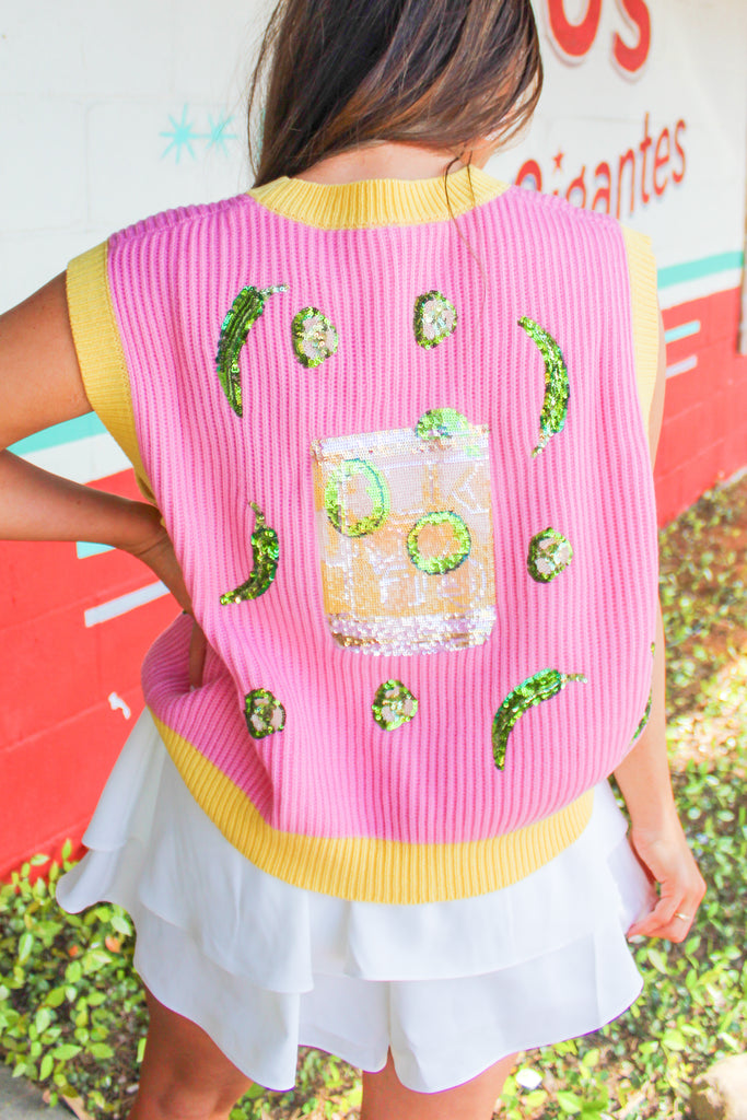 pink knit sweater vest with yellow outline, sequin patches and tinsel lettering
