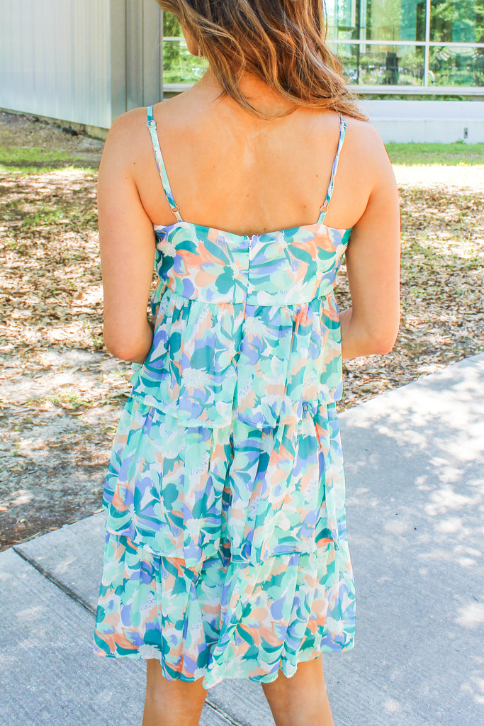 blue green and orange floral dress with a v-neck and tiered ruffles