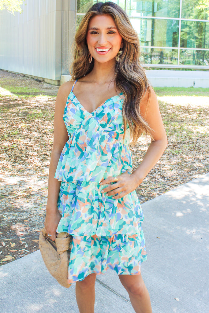 blue green and orange floral dress with a v-neck and tiered ruffles
