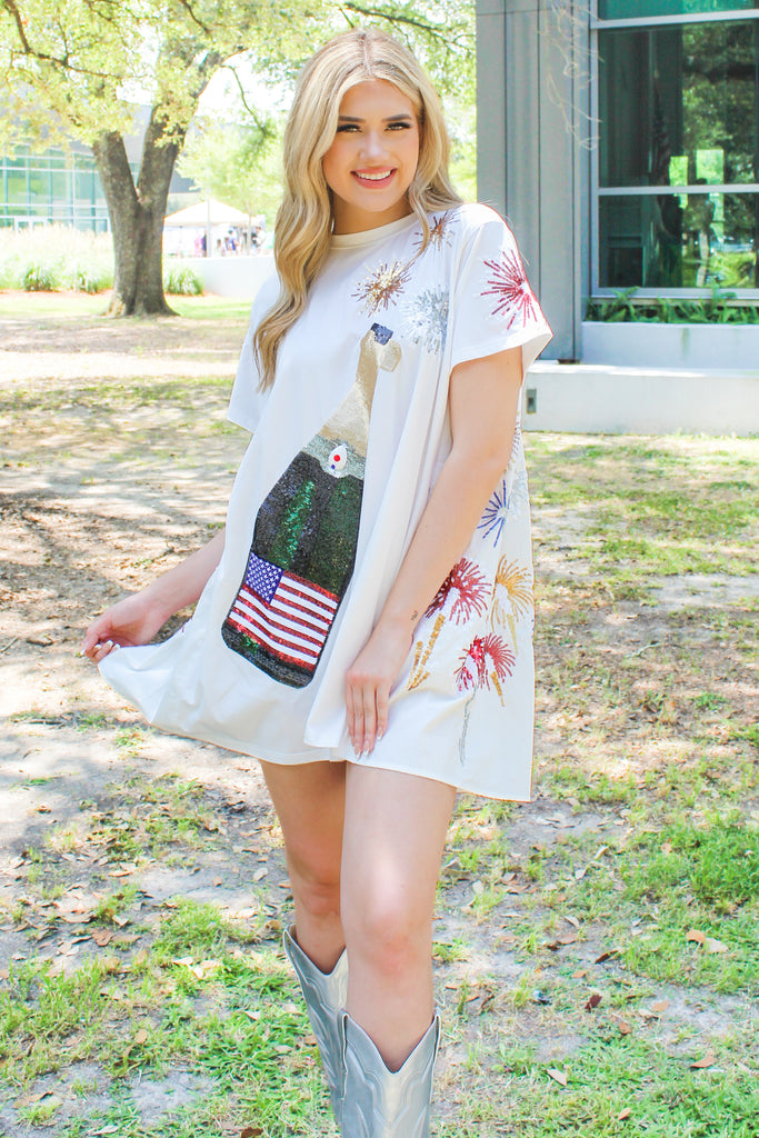 Queen of Sparkles USA Champagne Ivory T-Shirt Swing Dress with sequin firework details on the back and oversized sequin american flag bottle on the front with pockets