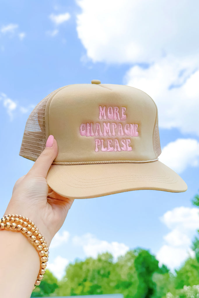 tan snapback trucker hat with embroidered lettering that reads more champagne please