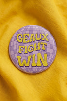 Geaux Fight Win Disco Button pinned on a yellow top