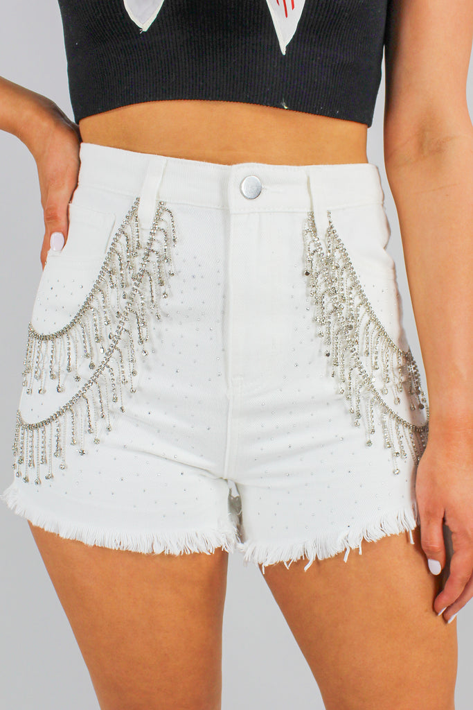 white denim shorts with rhinestone fringe detail along the front.