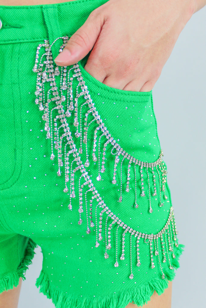 green denim shorts with rhinestone fringe detail along the front.