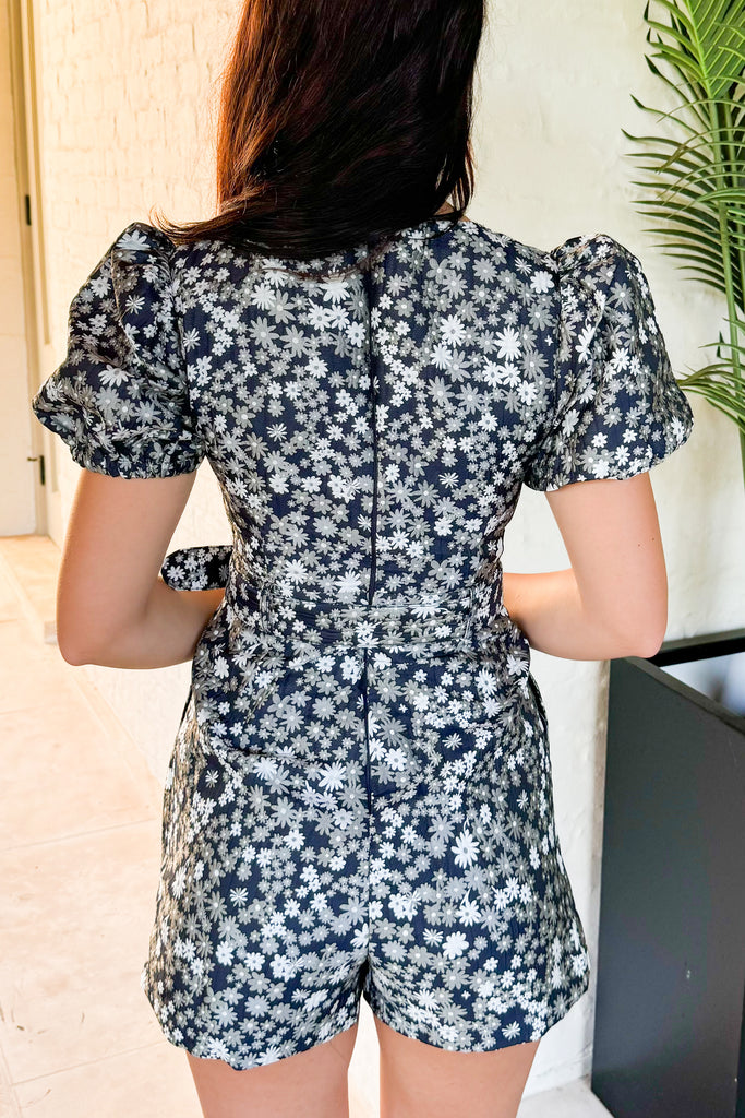 back of navy floral puff sleeve romper with waist belt