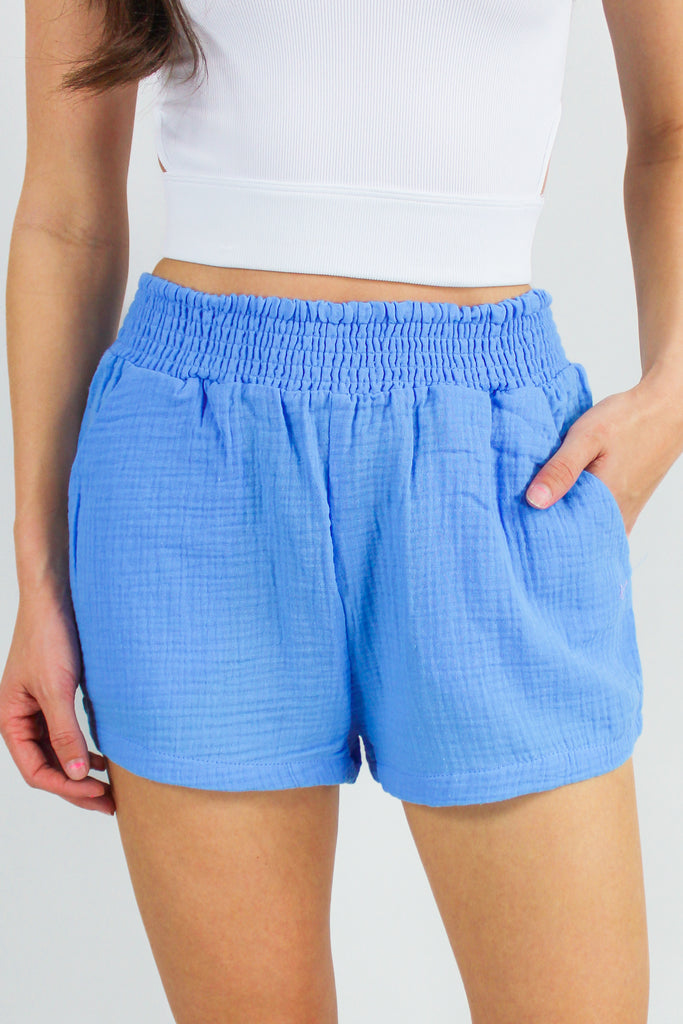 front view of blue gauze shorts with a smocked waist