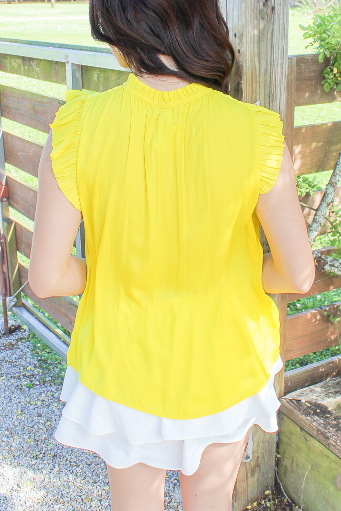 yellow pleated sleeve blouse with a tie detail around the neck