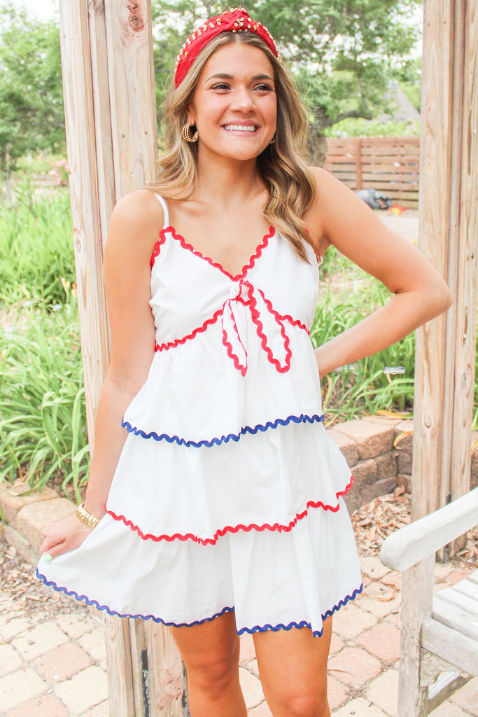 white tiered dress with red and blue trim detail