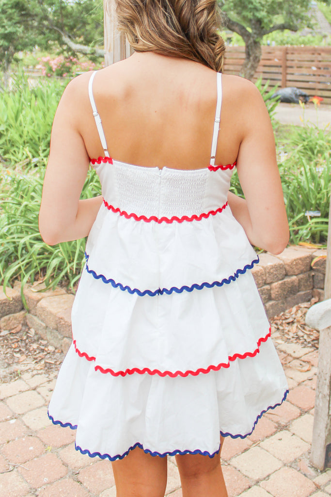 white tiered dress with red and blue trim detail