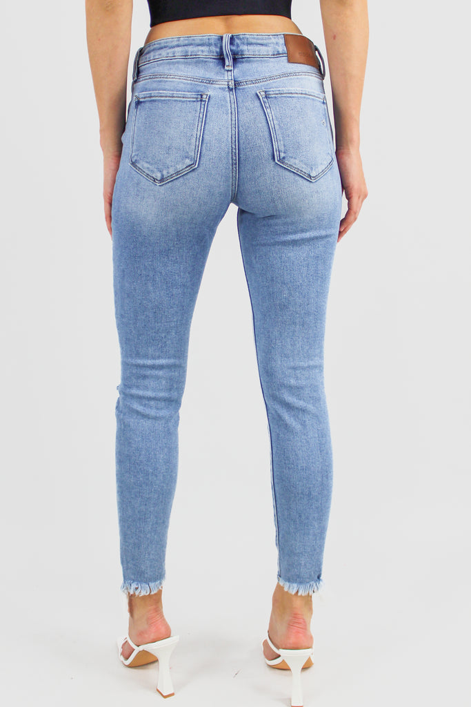 Medium denim distressed skinny jeans with a cropped hem and mis-rise fit.