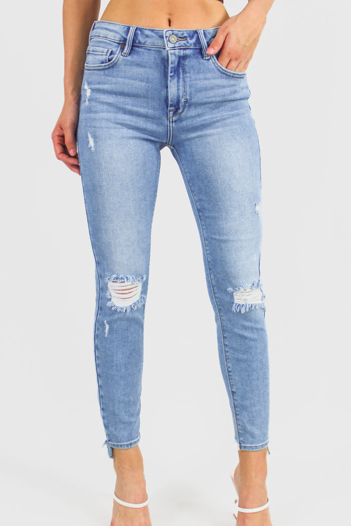 Medeium denim distressed skinny jeans with a cropped hem and mis-rise fit.