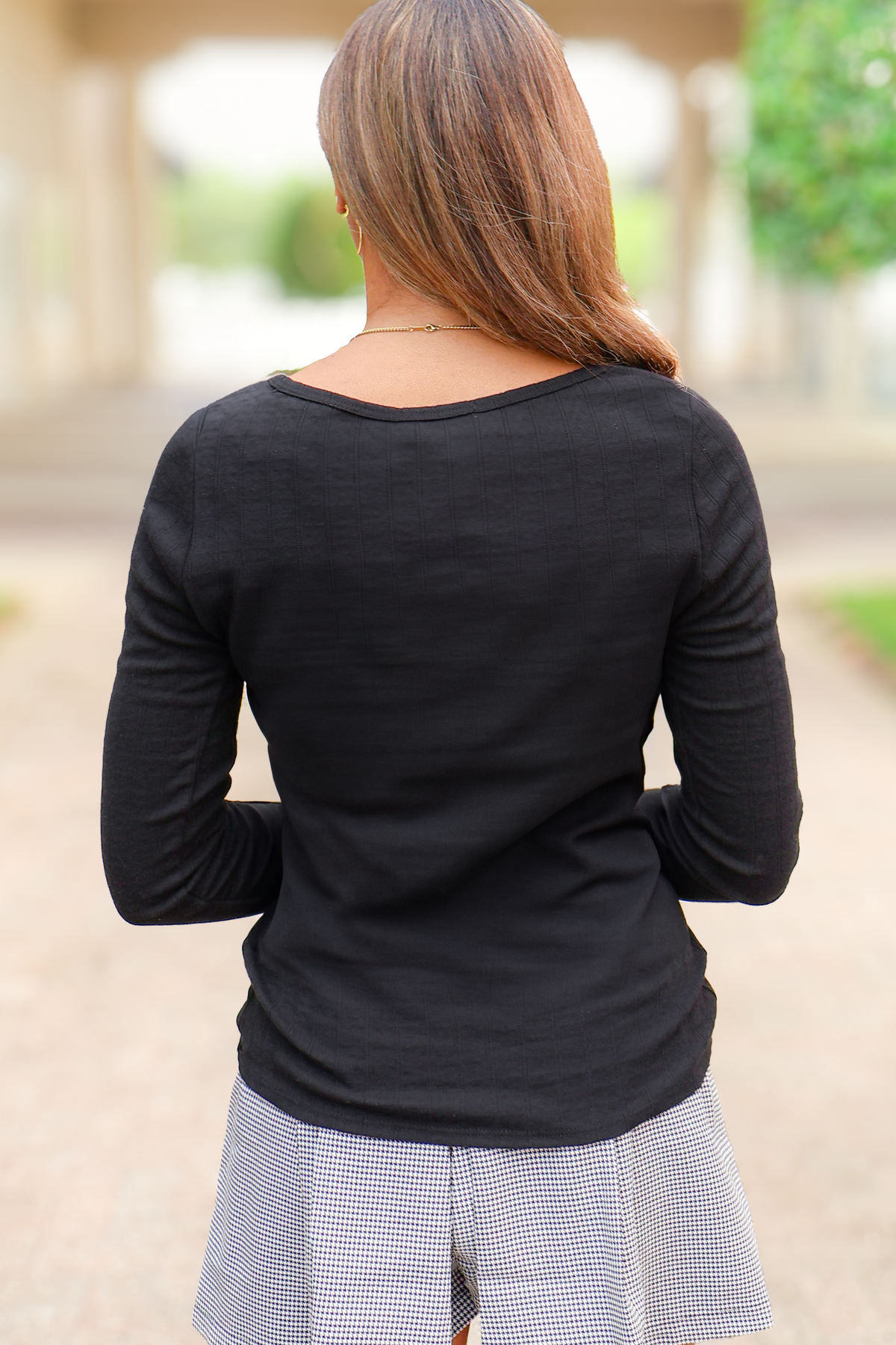 Black fitted ribbed long sleeve top, back view