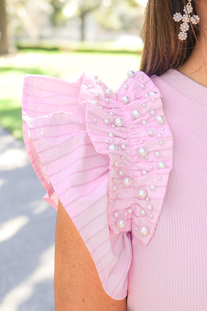 close up of pearl detail ruffle sleeve of light pink top 