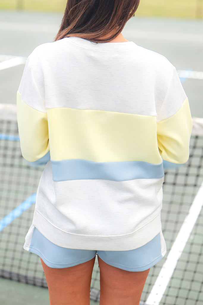 back of grey, blue and yellow colorblocked sweatshirt