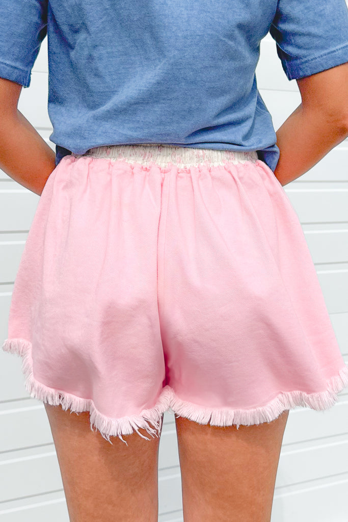 back of pink denim frayed hem skort with floral waistband