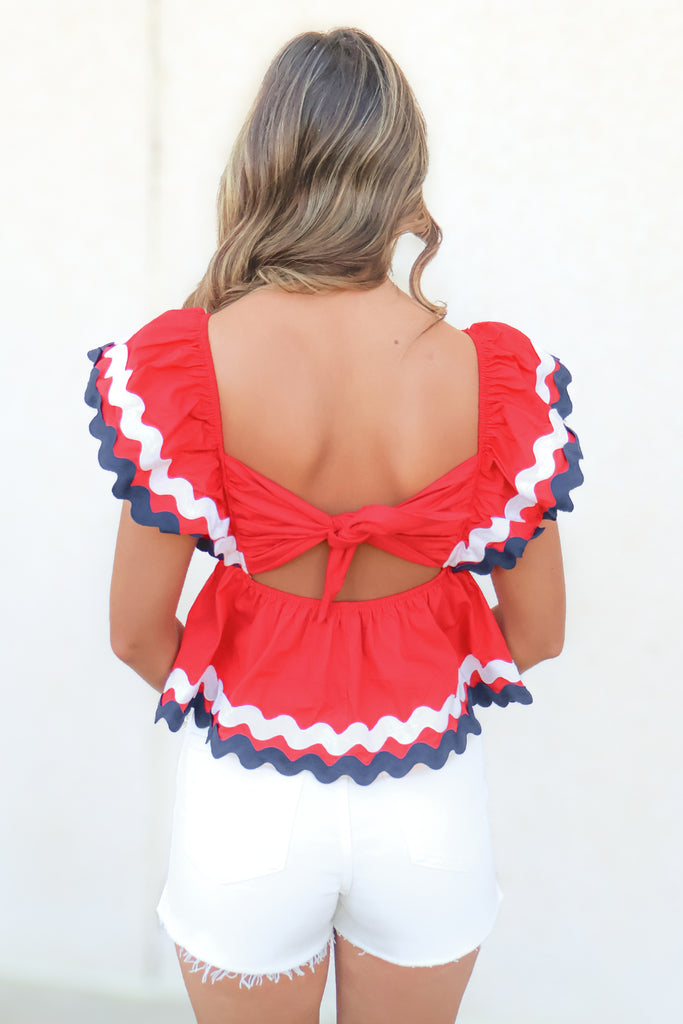 tie back of red babydoll top with white and blue wavy trim