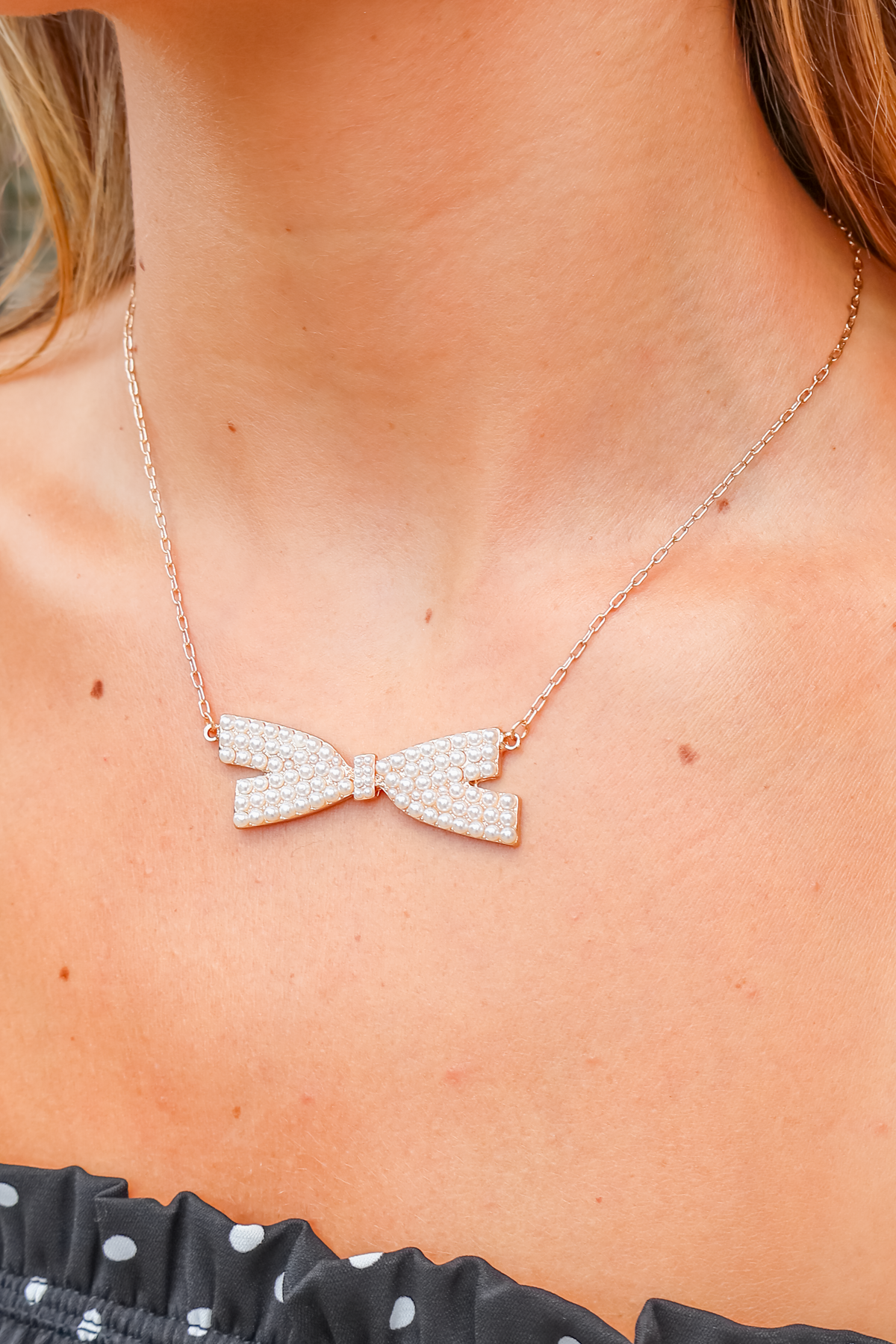 Gold pearl paved bow necklace