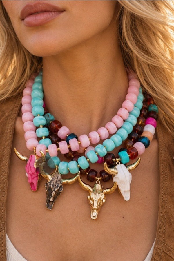 Wild and Free Bullhead Necklaces layered on a model in pink, teal and cognac